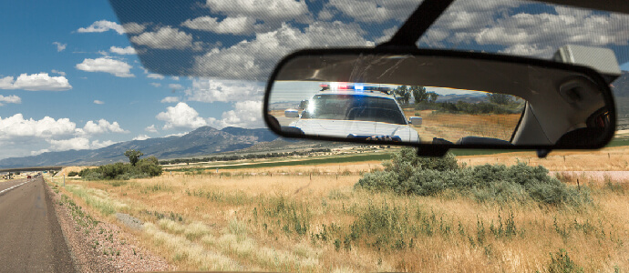 police car in rearview mirror while driving