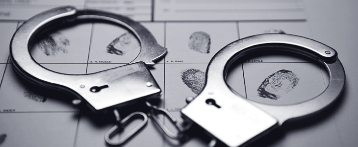 a pair of handcuff and fingerprints on a document indicating someone was accused of a sex crime in bradenton & sarasota florida