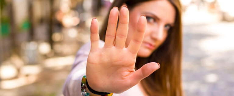 Woman with hand up towards camera